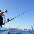 Hombre sujetando una caña de pescar y señalando el horizonte