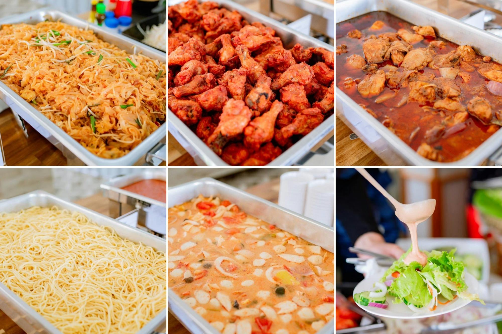 Μπουφές με διάφορα πιάτα, όπως τηγανητό κοτόπουλο, ζυμαρικά, χυλοπίτες, στιφάδο και σαλάτα. καρυκεύματα ορατά στο παρασκήνιο.