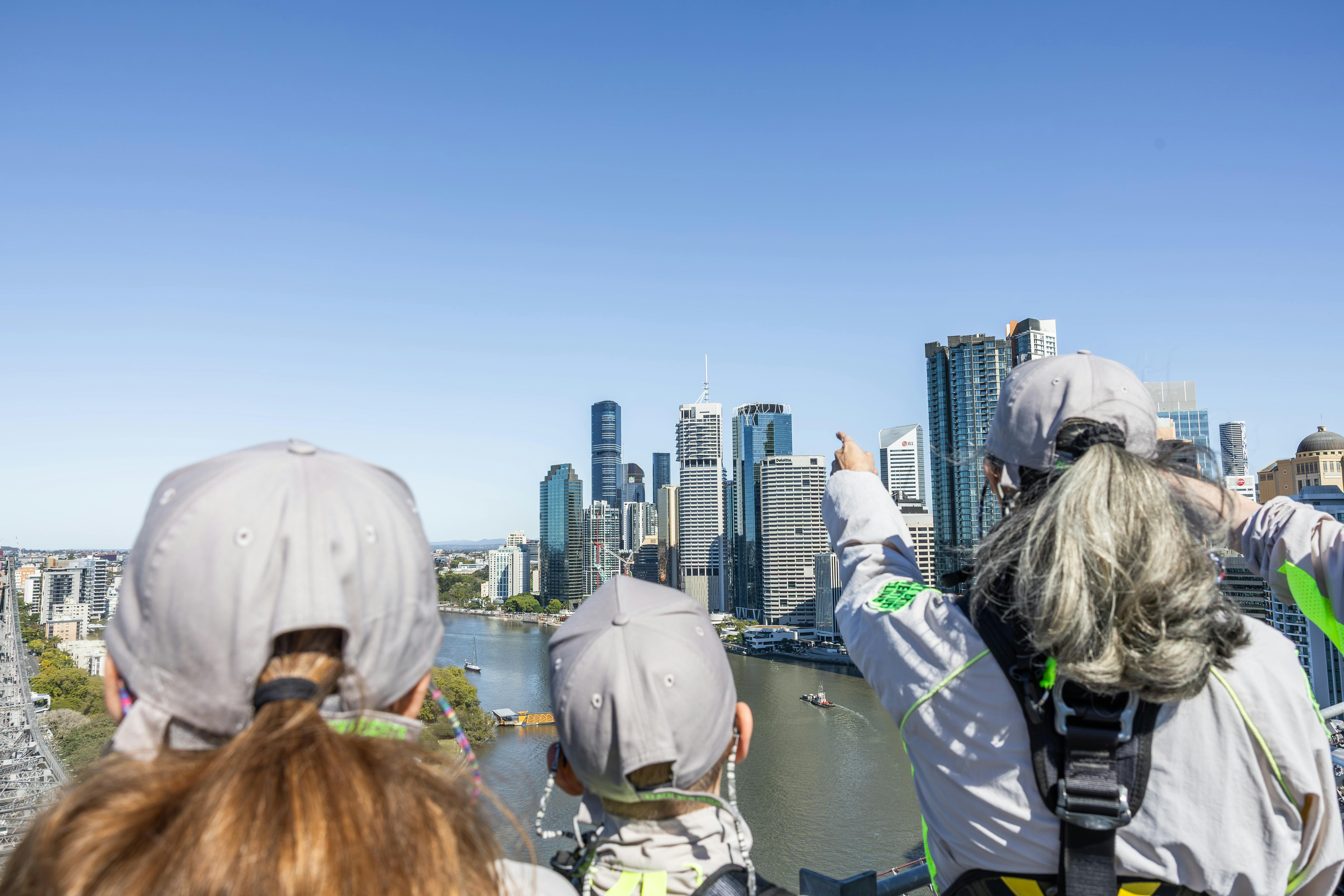 一群身穿蓝色衬衫的人爬上水面上的户外楼梯，背景是一艘蓝白相间的船。