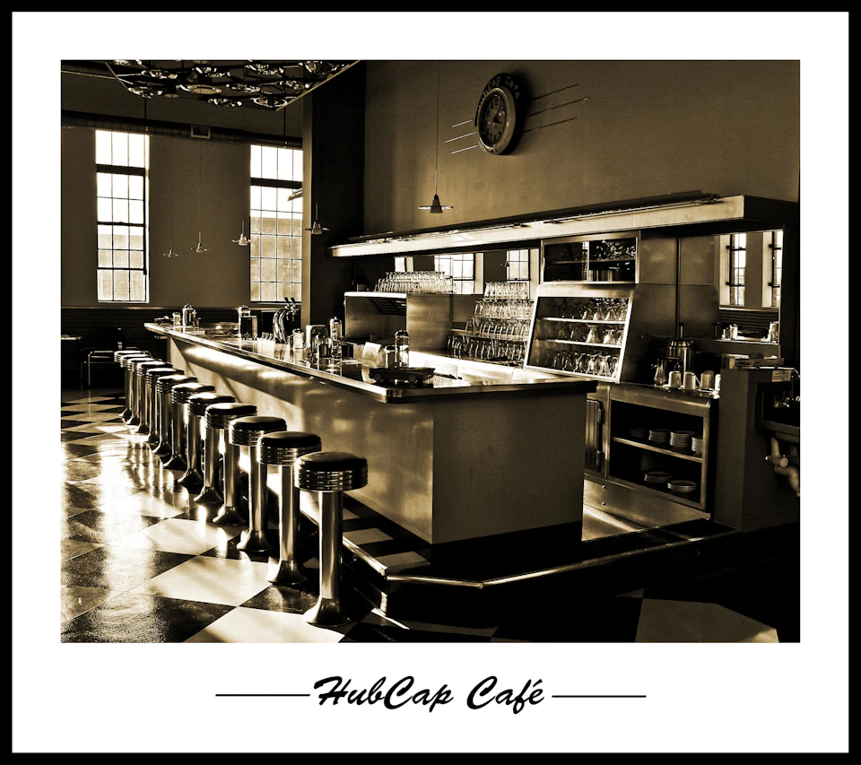A retro-styled café with a long counter, chrome bar stools, checkered floor, and large windows. "HubCap Café" is captioned below.