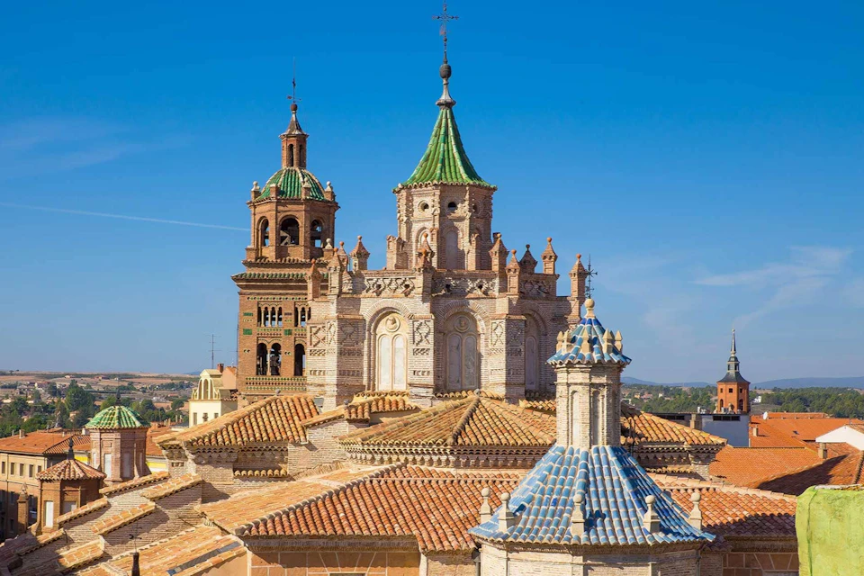 Historic buildings with ornate towers and tiled roofs under a clear blue sky.