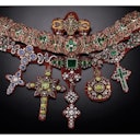 An ornate necklace adorned with colorful gemstones and intricate metalwork, featuring multiple large, elaborate pendants.
