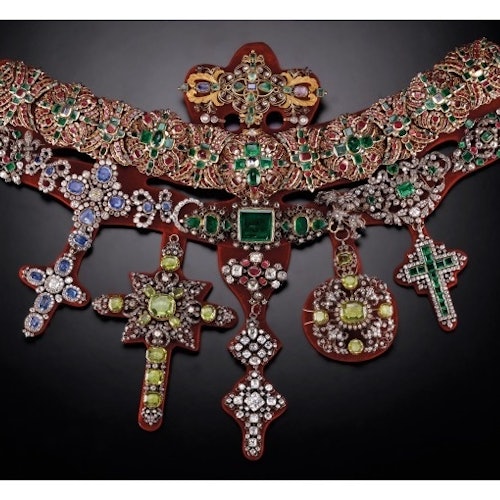 An ornate necklace adorned with colorful gemstones and intricate metalwork, featuring multiple large, elaborate pendants.