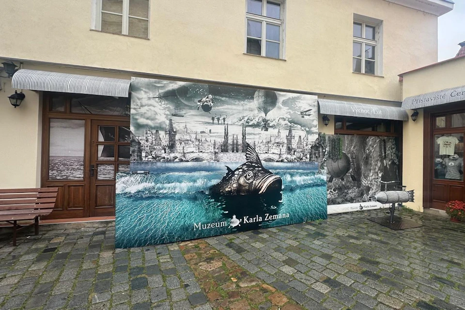 A mural outside the Karel Zeman Museum depicting a surreal scene with a fish in water and a fantastical cityscape above.