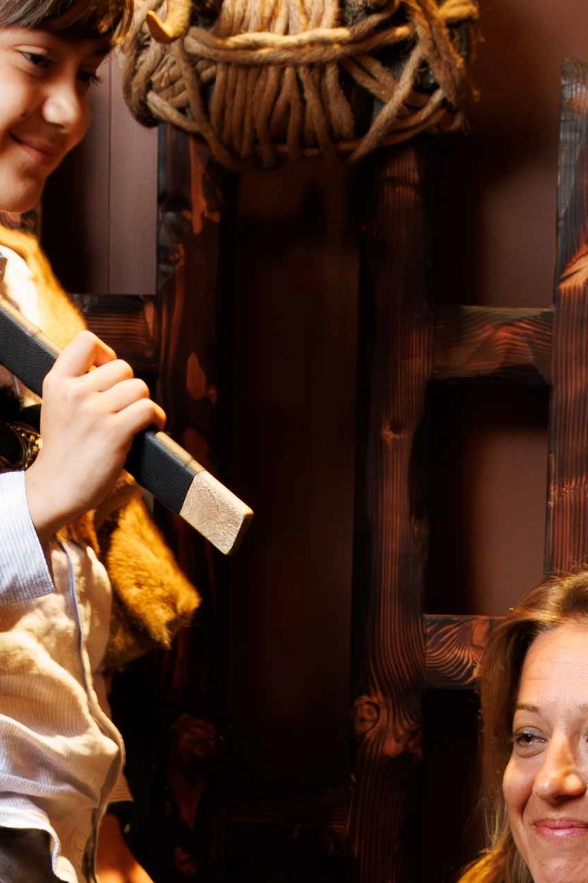 A group dressed in medieval costumes, with one person sitting on a wooden throne, surrounded by antlers and holding wooden swords.