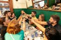 Happy guests raising their glasses, enjoying the Eixample food tour in a cozy setting.