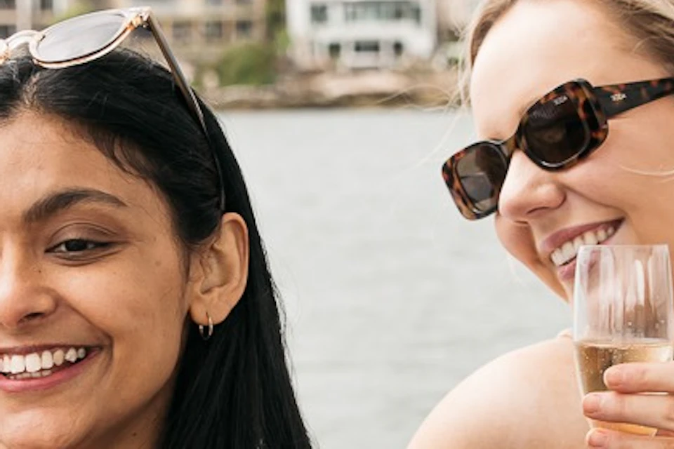 Two guests onboard a GoBoat, sharing some food \ drinks taking a selfie