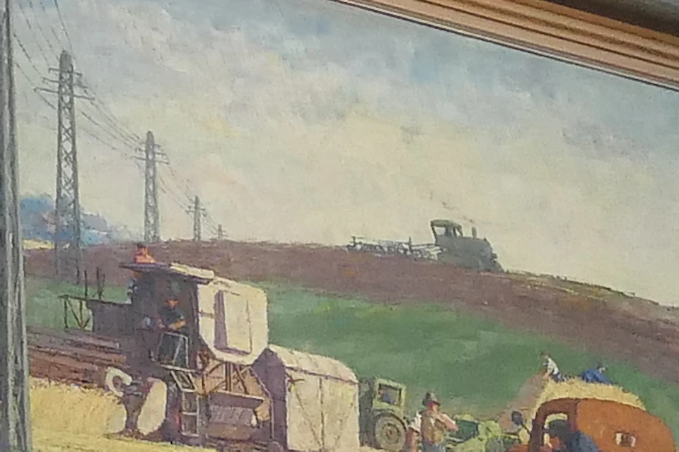 Wall displaying multiple socialist-themed paintings, including figures in rural settings and industrial scenes, labeled "The Socialist Hero."
