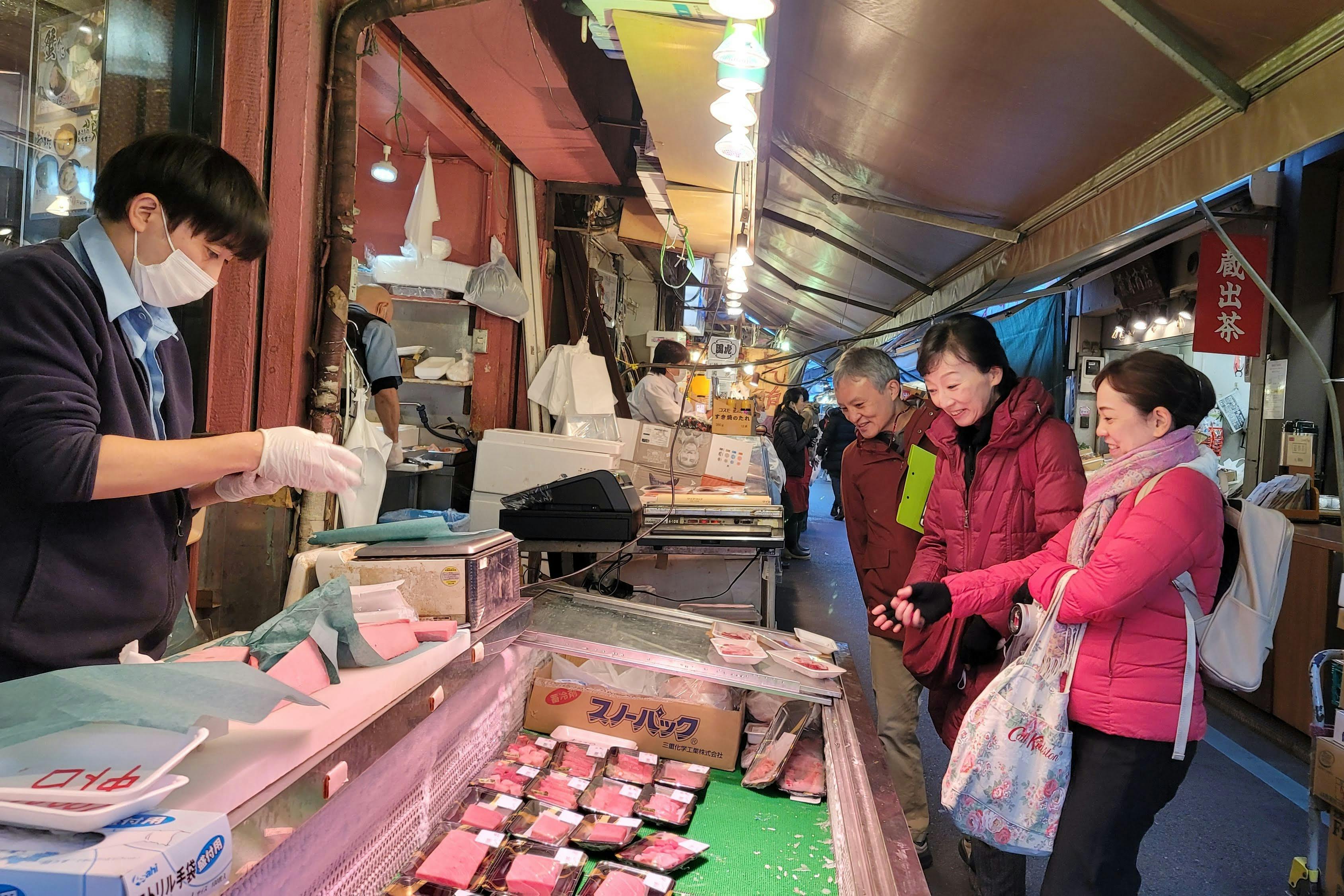 Tourists choosing sashimi at Tsukiji Market