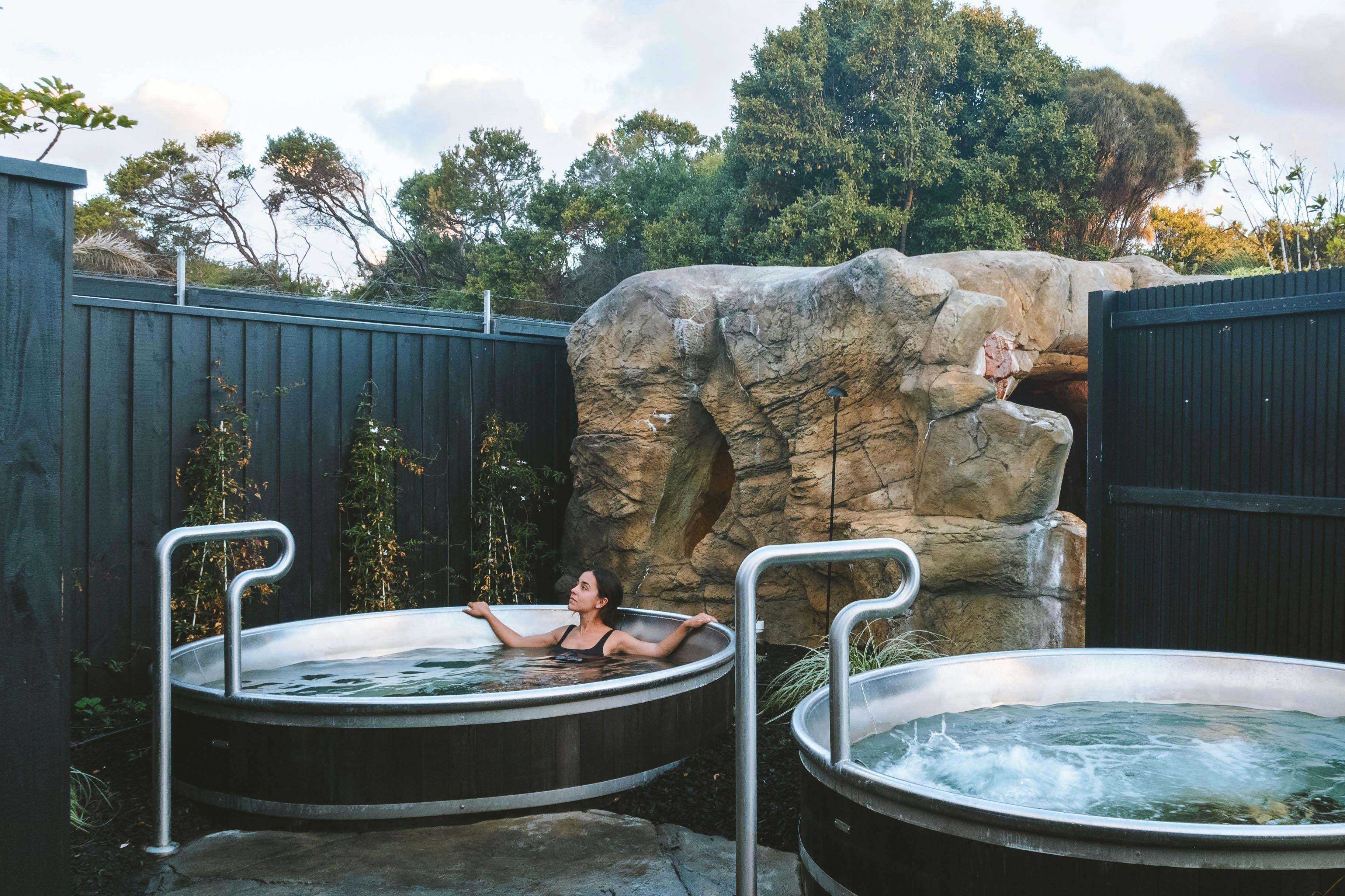 Donna rilassata mentre si immerge in una vasca minerale rotonda