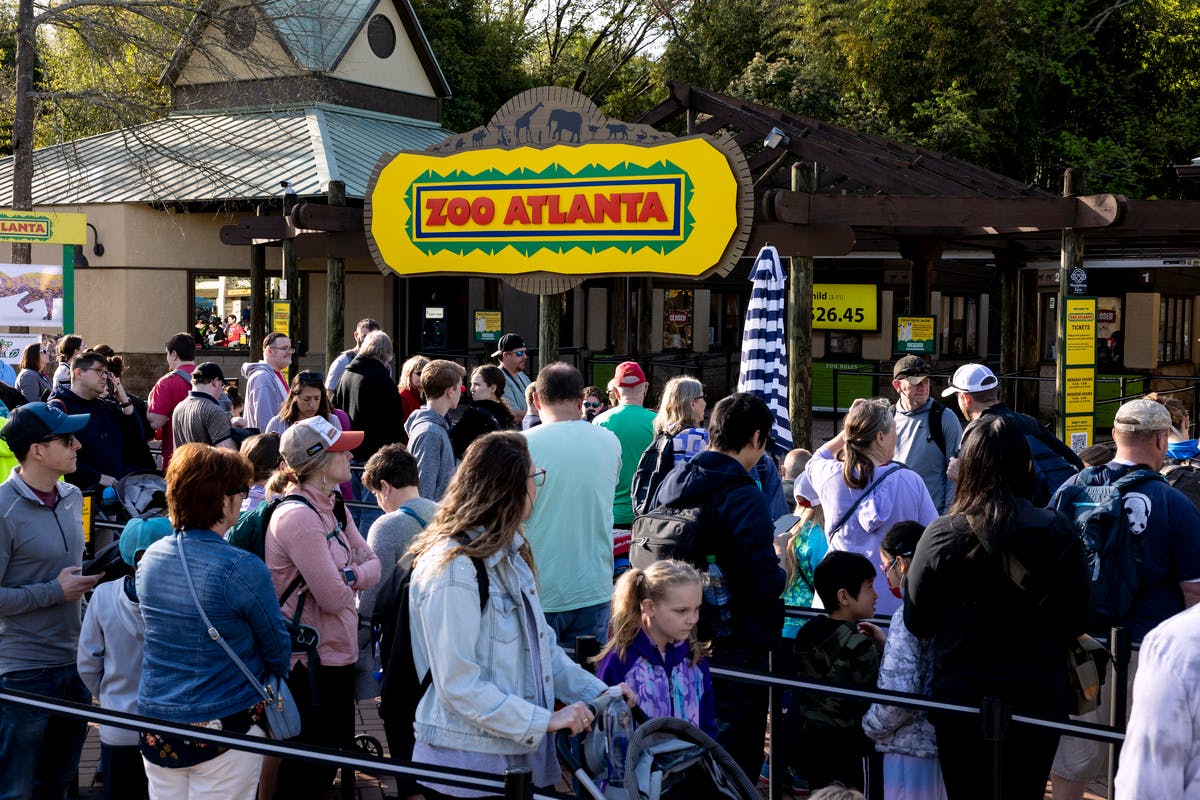 En menneskemængde samledes ved indgangen til Zoo Atlanta, med zooens skilt tydeligt over porten.