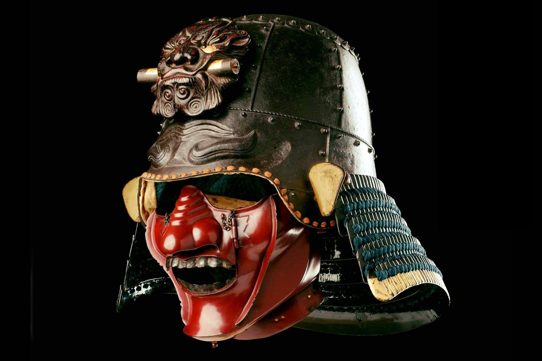 传统的日本武士头盔，配有红色面罩和复杂的装饰，显示在黑色背景上。
