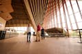 Viajantes admirados com a arquitetura e a solução esférica das conchas da Opera House