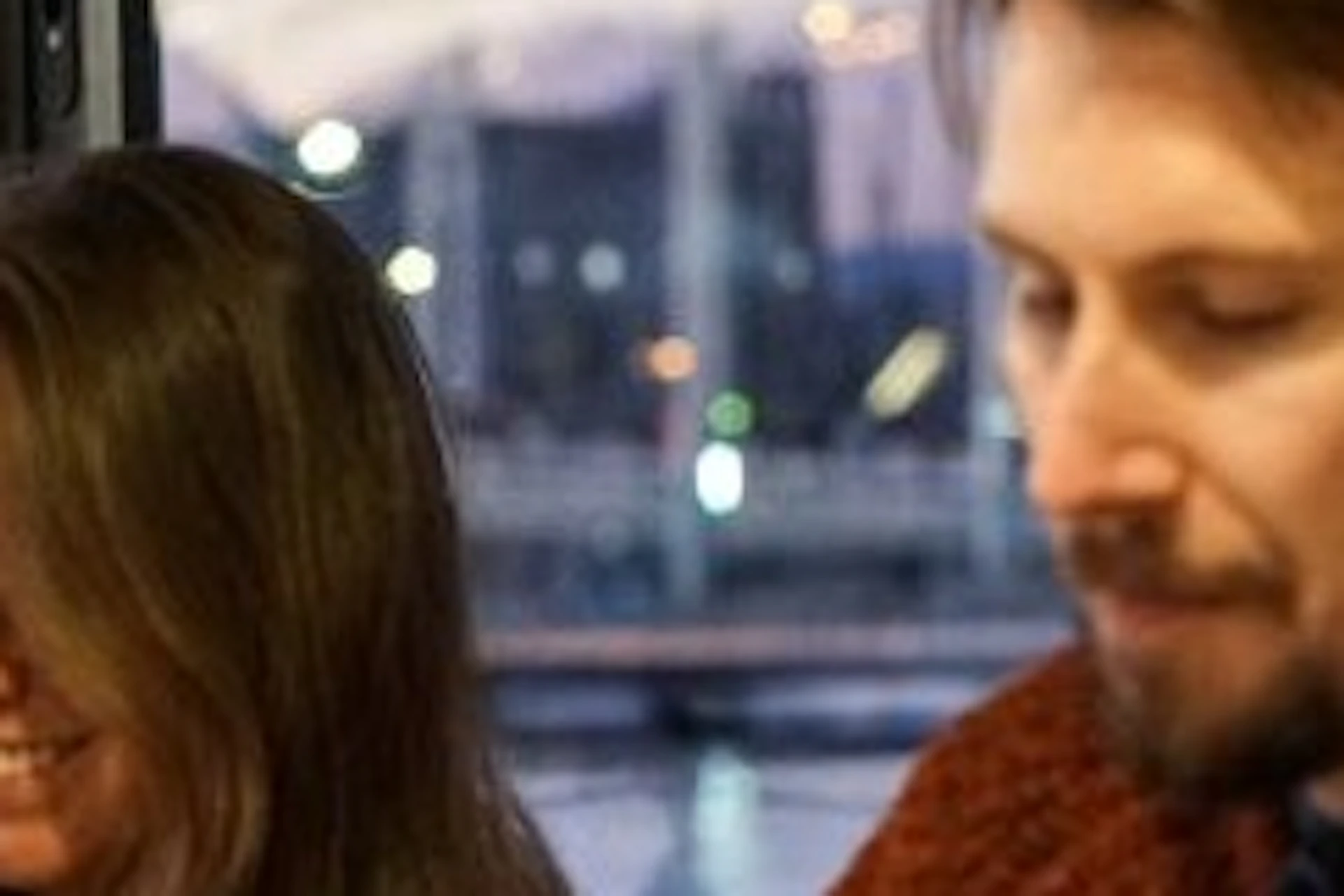 Two people sitting at a table and having dinner on a catamaran.
