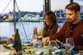 Duas pessoas sentadas em uma mesa e jantando em um catamarã.