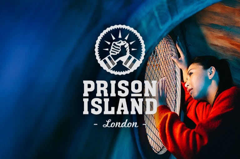 En kvinna i en röd tröja tittar genom ett runt, mesh-täckt fönster. Texten lyder "Prison Island London" med en handslagslogotyp.