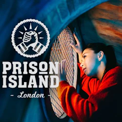 En kvinna i en röd tröja tittar genom ett runt, mesh-täckt fönster. Texten lyder "Prison Island London" med en handslagslogotyp.