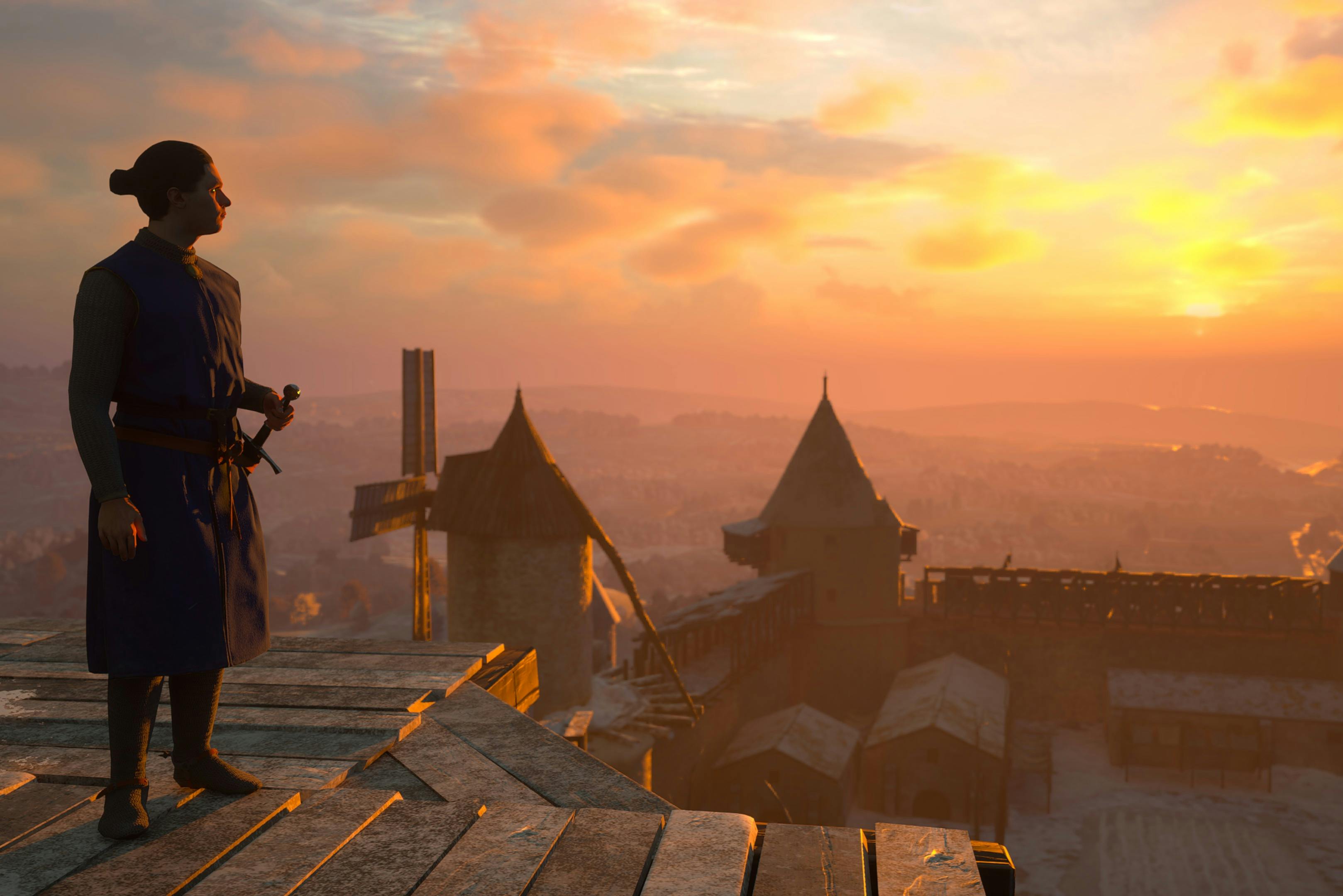 Person with a sword stands on a wooden platform overlooking a medieval-style village at sunset, featuring stone towers and a windmill.