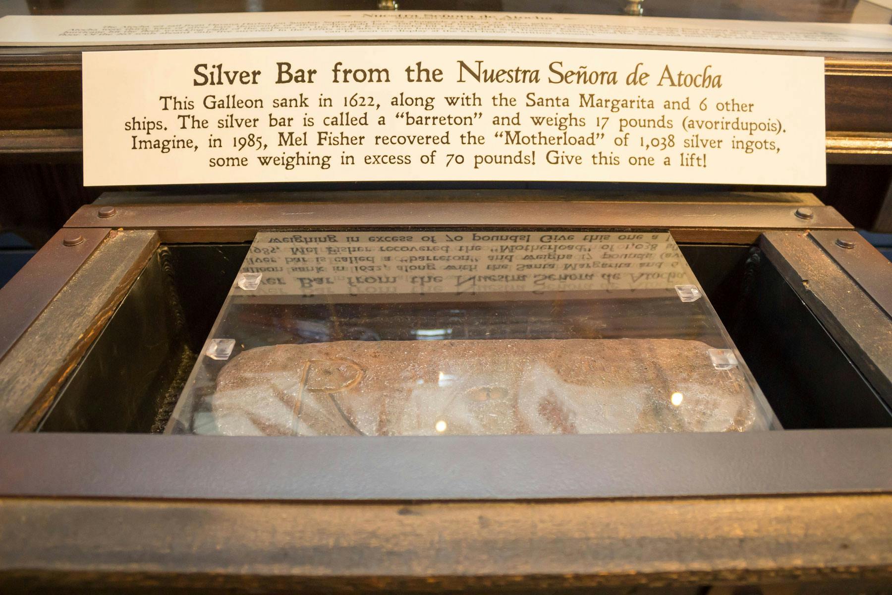 Displayfodral som innehåller en silvertacka med en informationsplakett om skeppsbrottet Nuestra Señora de Atocha.