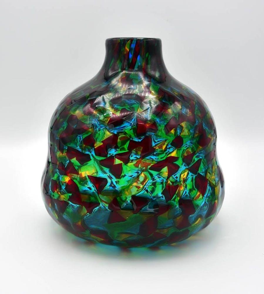 빨간색, 녹색 및 파란색의 추상적 인 패턴이 특징 인 구근 모양과 좁은 목이있는 여러 가지 빛깔의 유리 꽃병.
