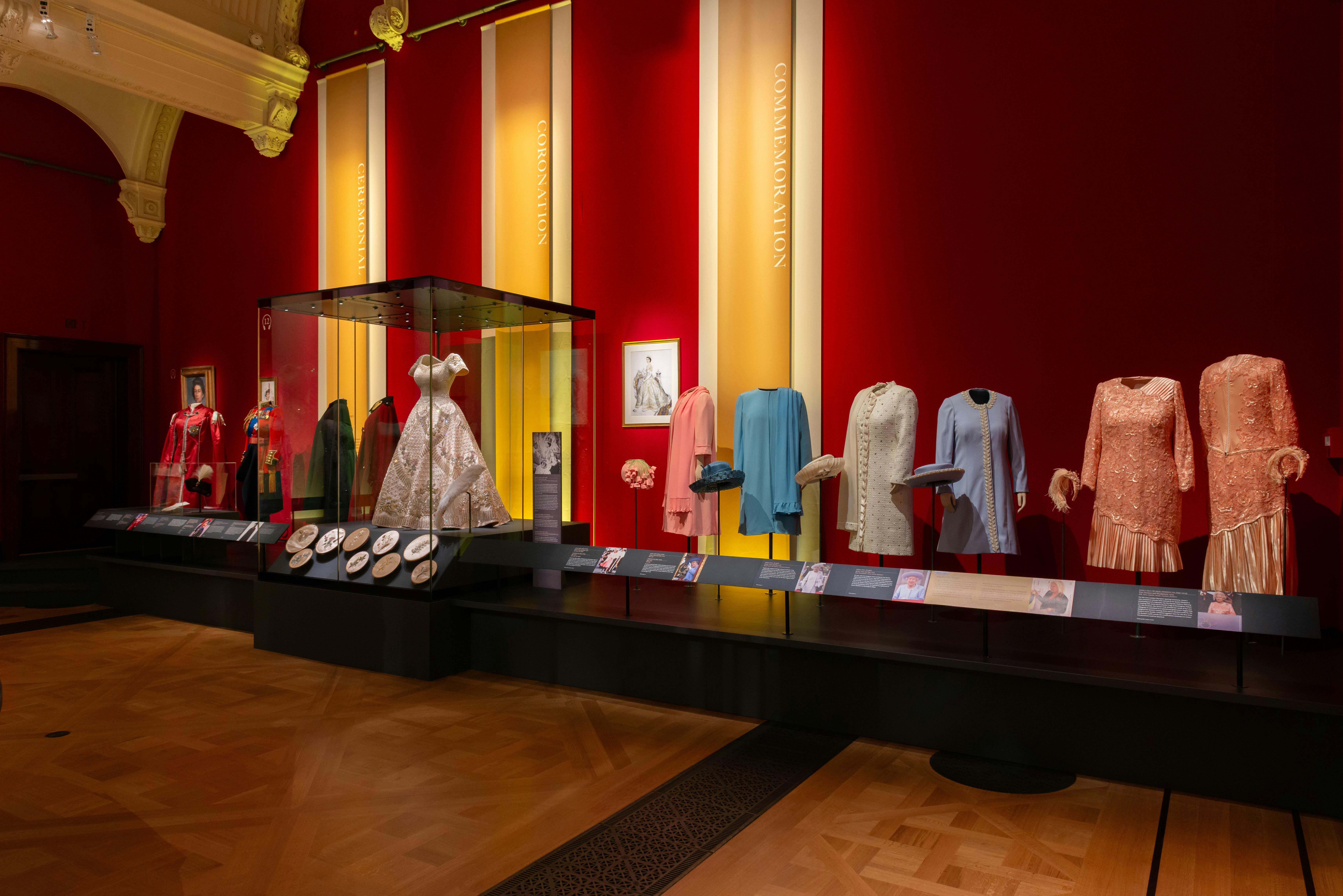 Ένα μουσειακό έκθεμα με vintage ρούχα που εκτίθενται σε μανεκέν και σε μια γυάλινη θήκη, με ενημερωτικές πλάκες παρακάτω.