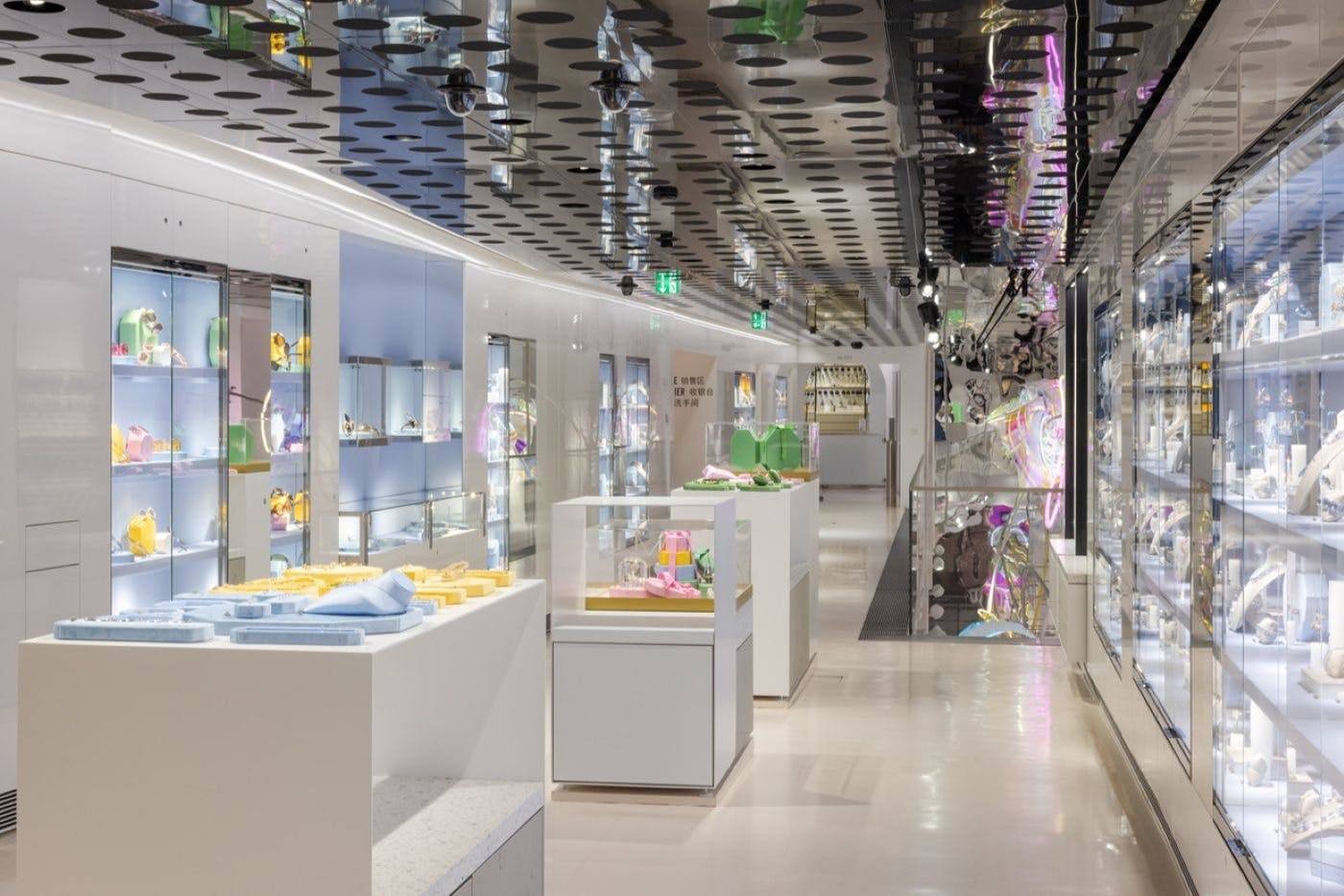 现代化的商店内部装饰有玻璃展示柜、各种彩色物品的架子和圆形图案的反光天花板。