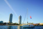 Naše plachetnice pluje podél barcelonského pobřeží.