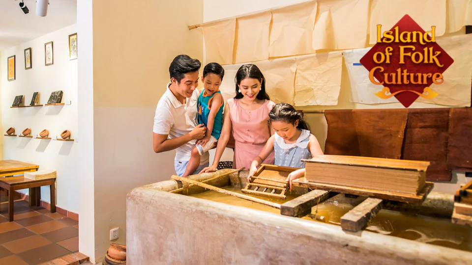 A family of four engaging in a papermaking activity, with children working on frames and adults observing closely.