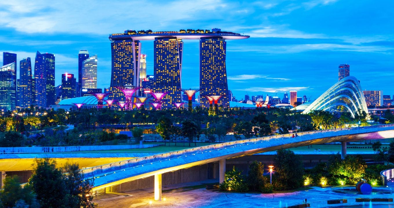 Městská panoráma za soumraku s Marina Bay Sands, Supertree Grove a osvětlenými budovami v pozadí.