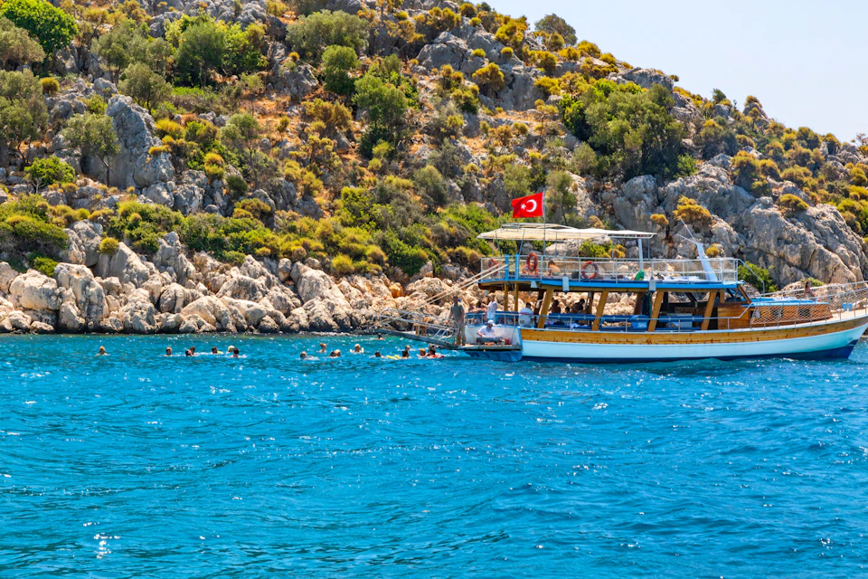 The beautiful coast of the Mediterranean near Kekova and the tourist's boats in Gokkaya Cove.