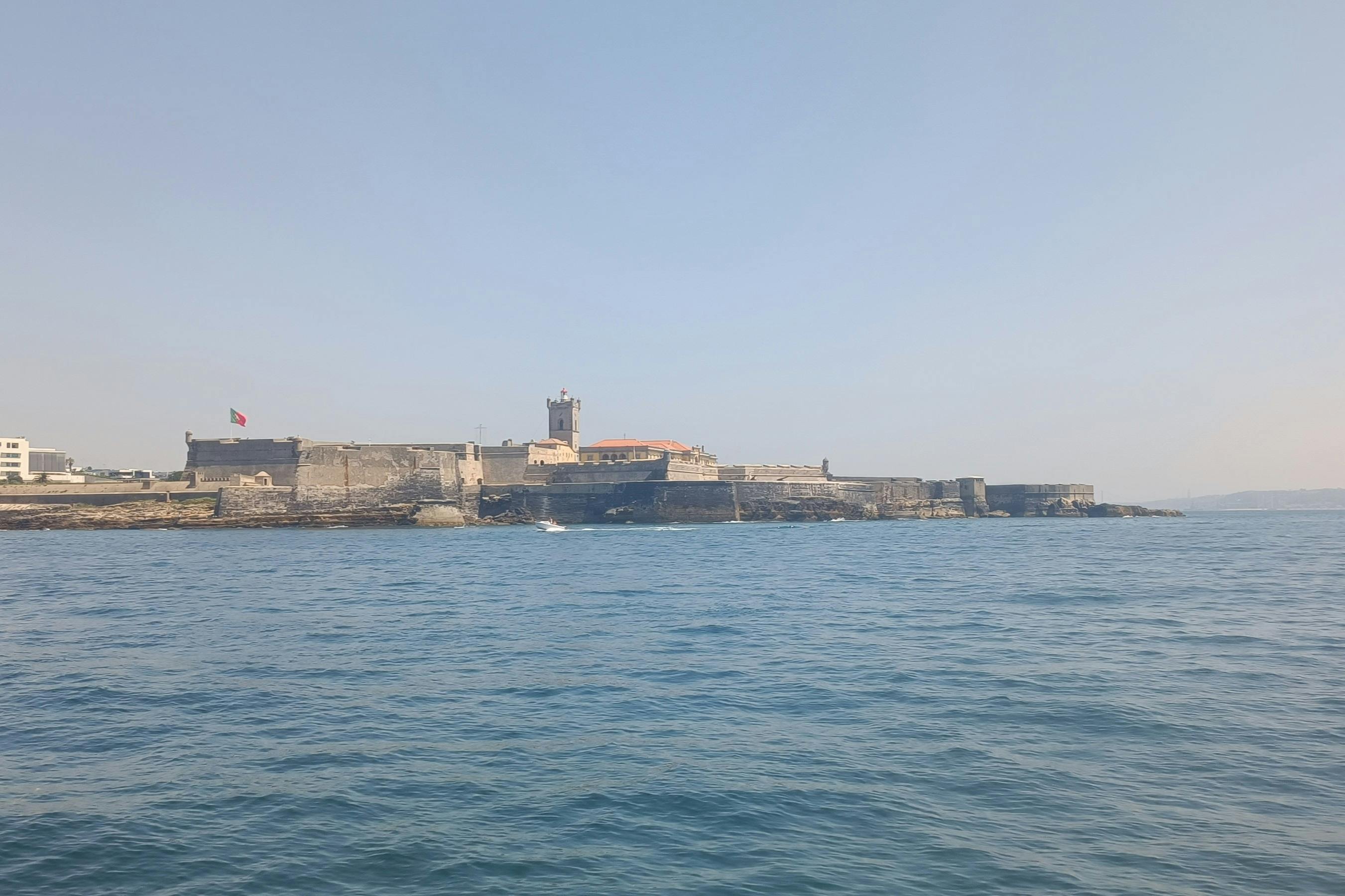 晴れた日に水上から見ることができる、石垣と塔がある海岸沿いの要塞。