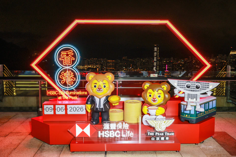 A display featuring lion mascots, neon signs, and The Peak Tram logo at a rooftop location with a cityscape in the background.