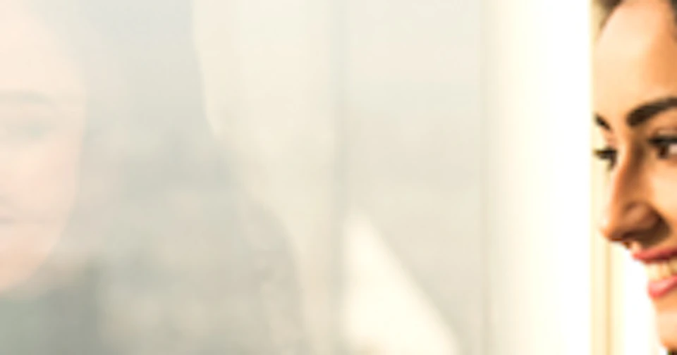 A man, woman, and child observe a digital display showing a cityscape from a high-rise window.