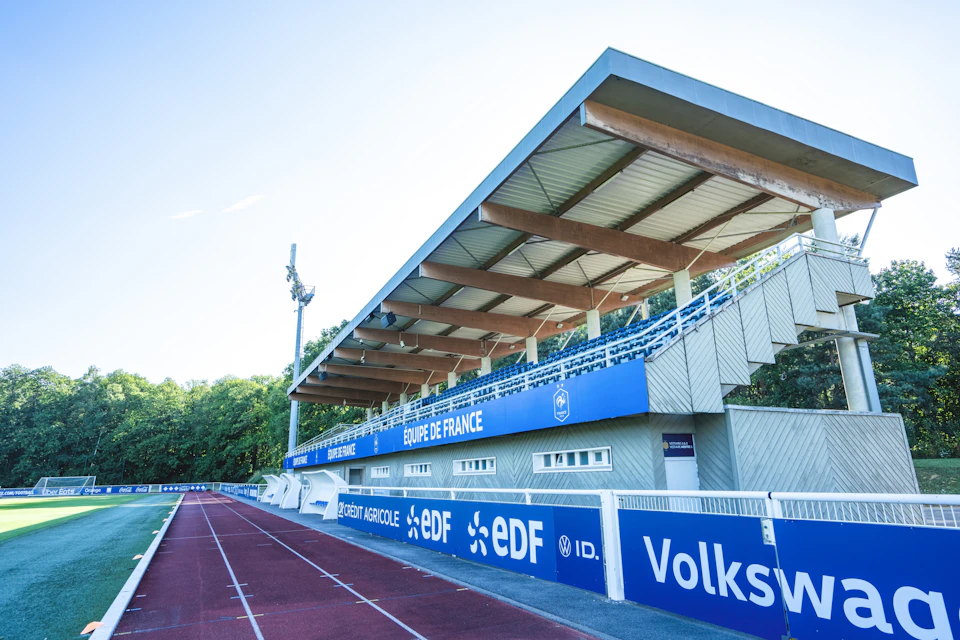 A sports stadium with a covered seating area labeled "Equipe de France" and a running track in the foreground.
