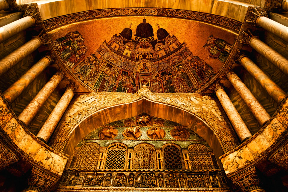 An ornate golden mosaic depicting religious figures and architecture, with intricate patterns and designs on the walls and ceiling.