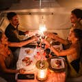 Ein befreundetes Paar genießt ein romantisches Abendessen an Bord einer Yacht.