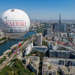 En luftballong med "Generali" -märket flyter över Paris, med Eiffeltornet och floden Seine i bakgrunden.