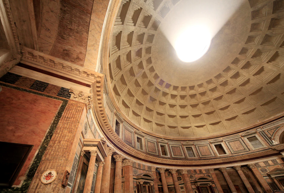 Interior view of the Pantheon's dome with its central oculus, showcasing the coffered concrete ceiling and classical columns below.