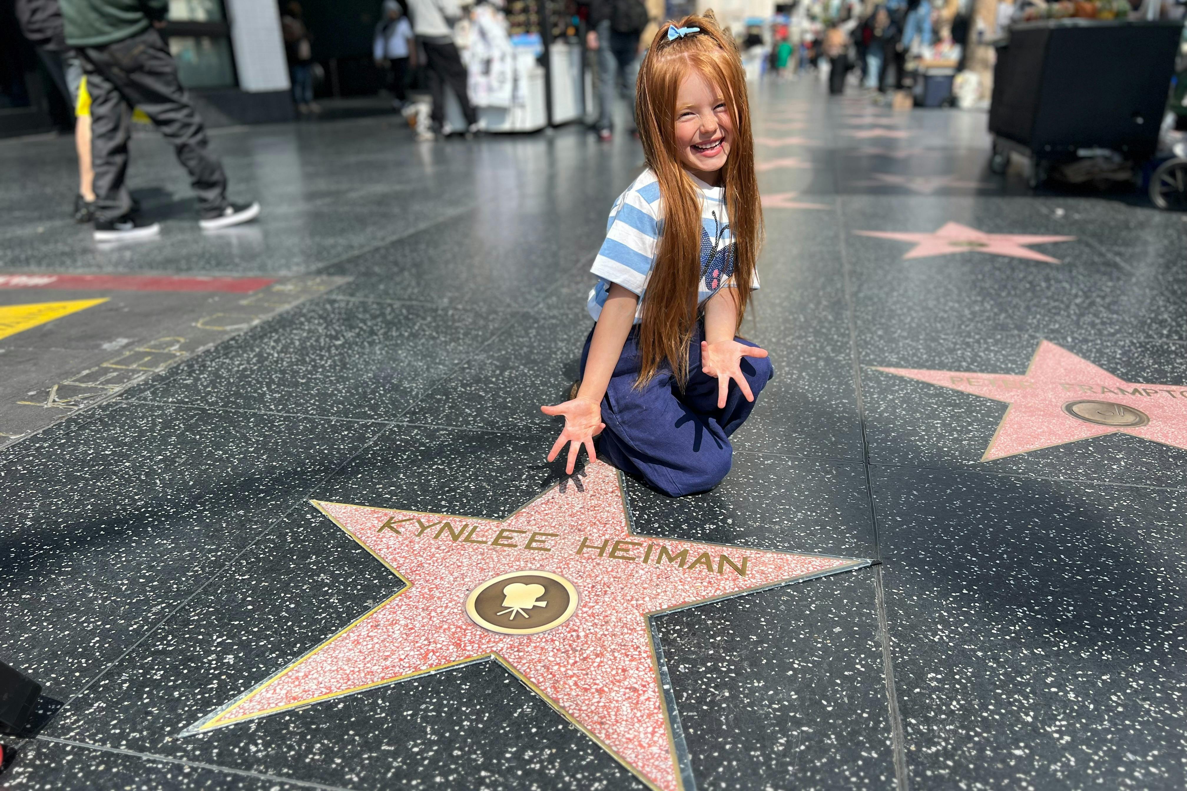 A  Hollywood Walk of Fame area  Tourist is happy with their own replica star personalized for a photo.#kids