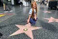 Un touriste de la zone Hollywood Walk of Fame est heureux d'avoir sa propre réplique d'étoile personnalisée pour une photo.