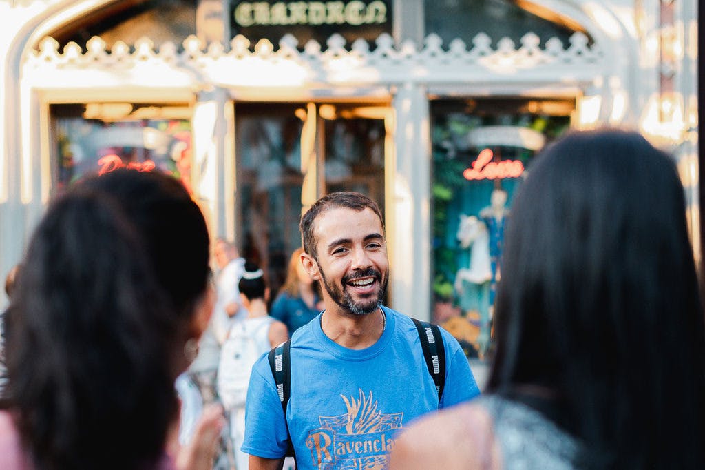 The guide is smiling in front of a bookstore