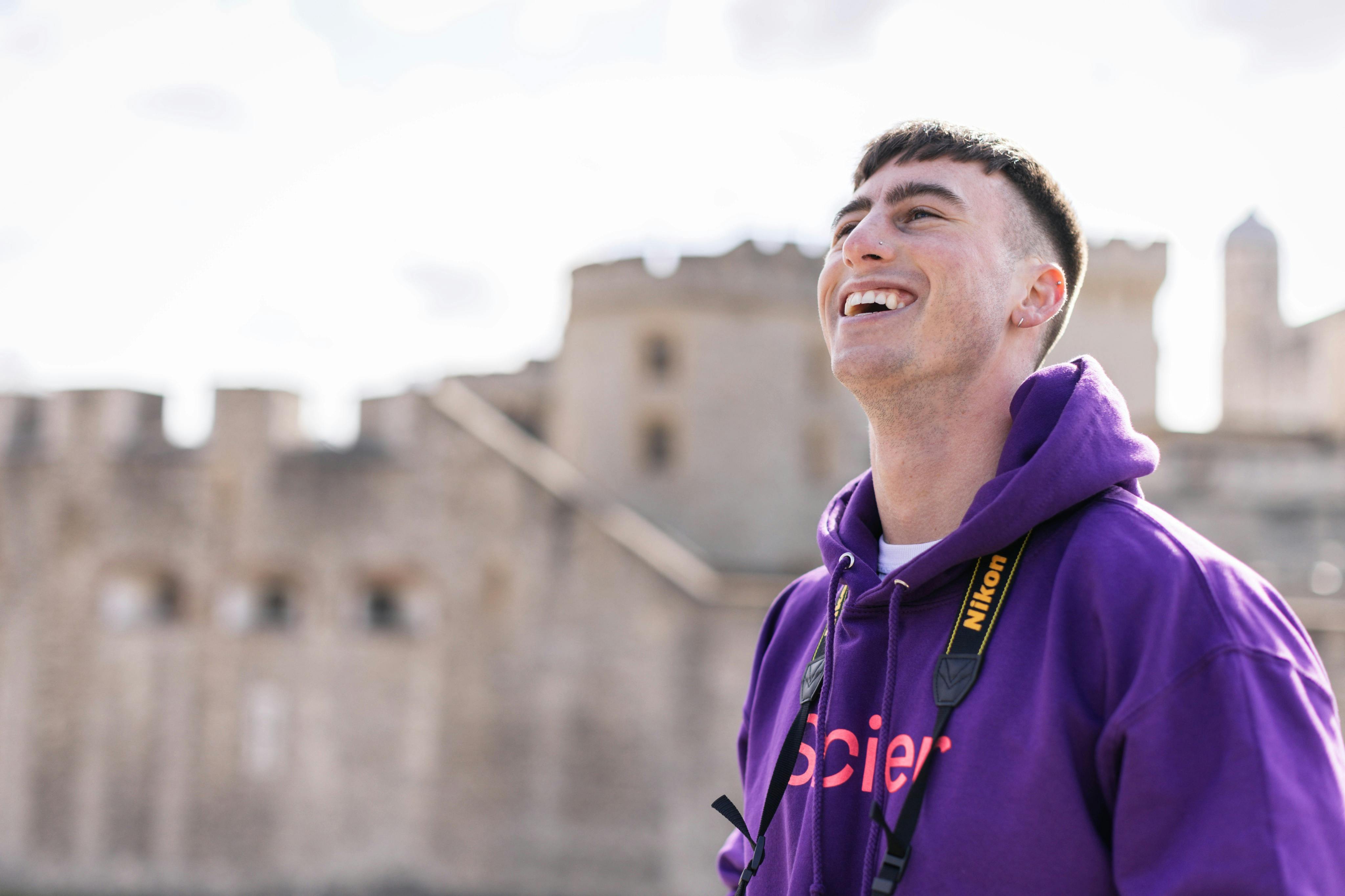 A photographer is smiling outside the Tower of London.