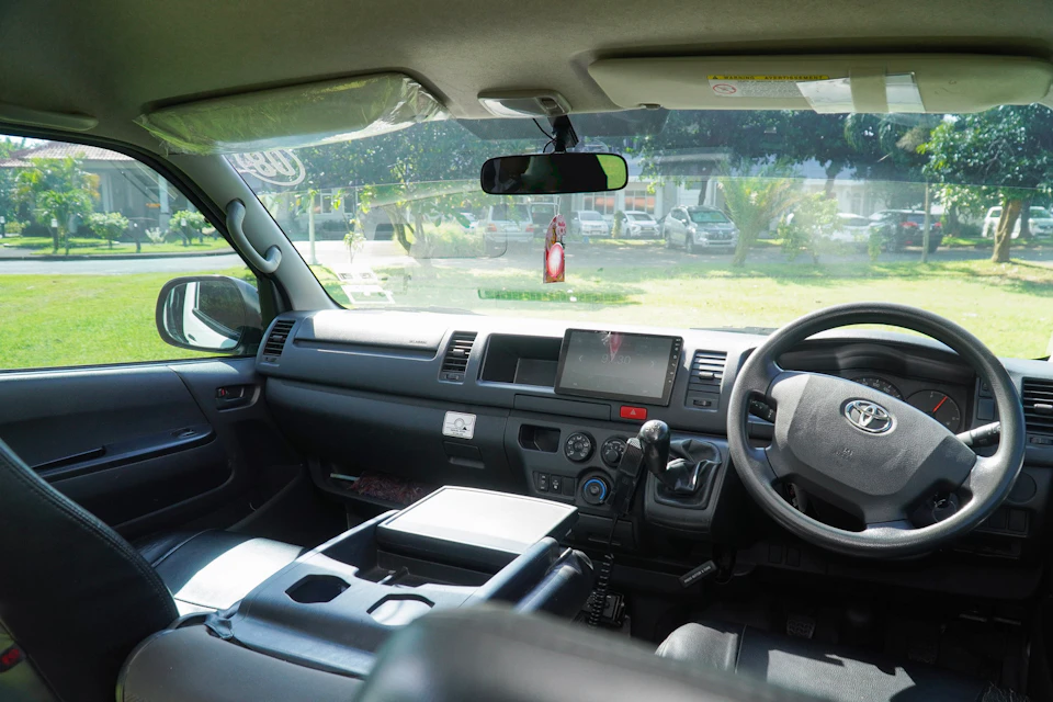 Interior view of a vehicle showing the dashboard, steering wheel, center console, and outside view through the windshield.