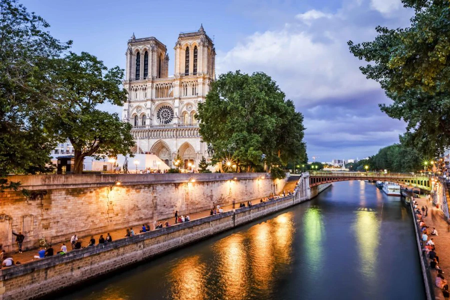 Notre-Dame bij schemering met verlichte weerspiegelingen in de Seine