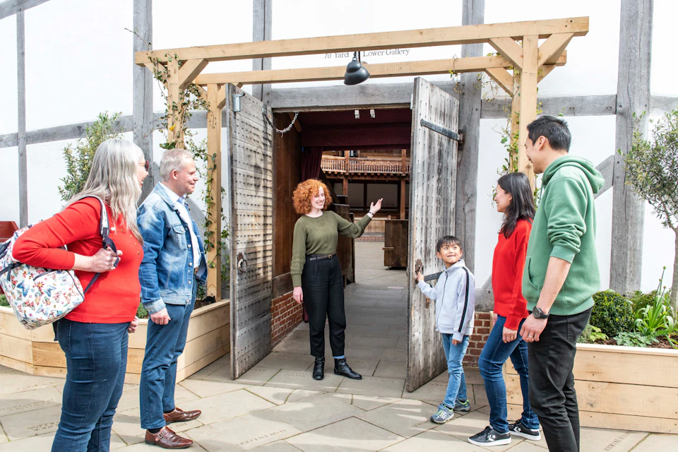 The tour group stood at one of the entrance doors of the Globe Theatre.