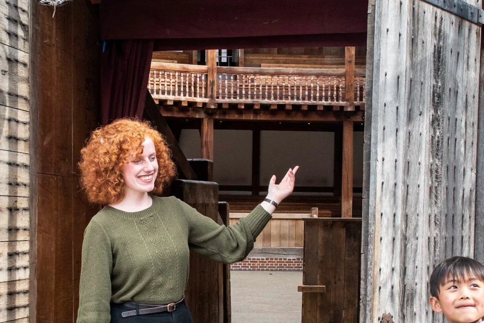 The tour group stood at one of the entrance doors of the Globe Theatre.
