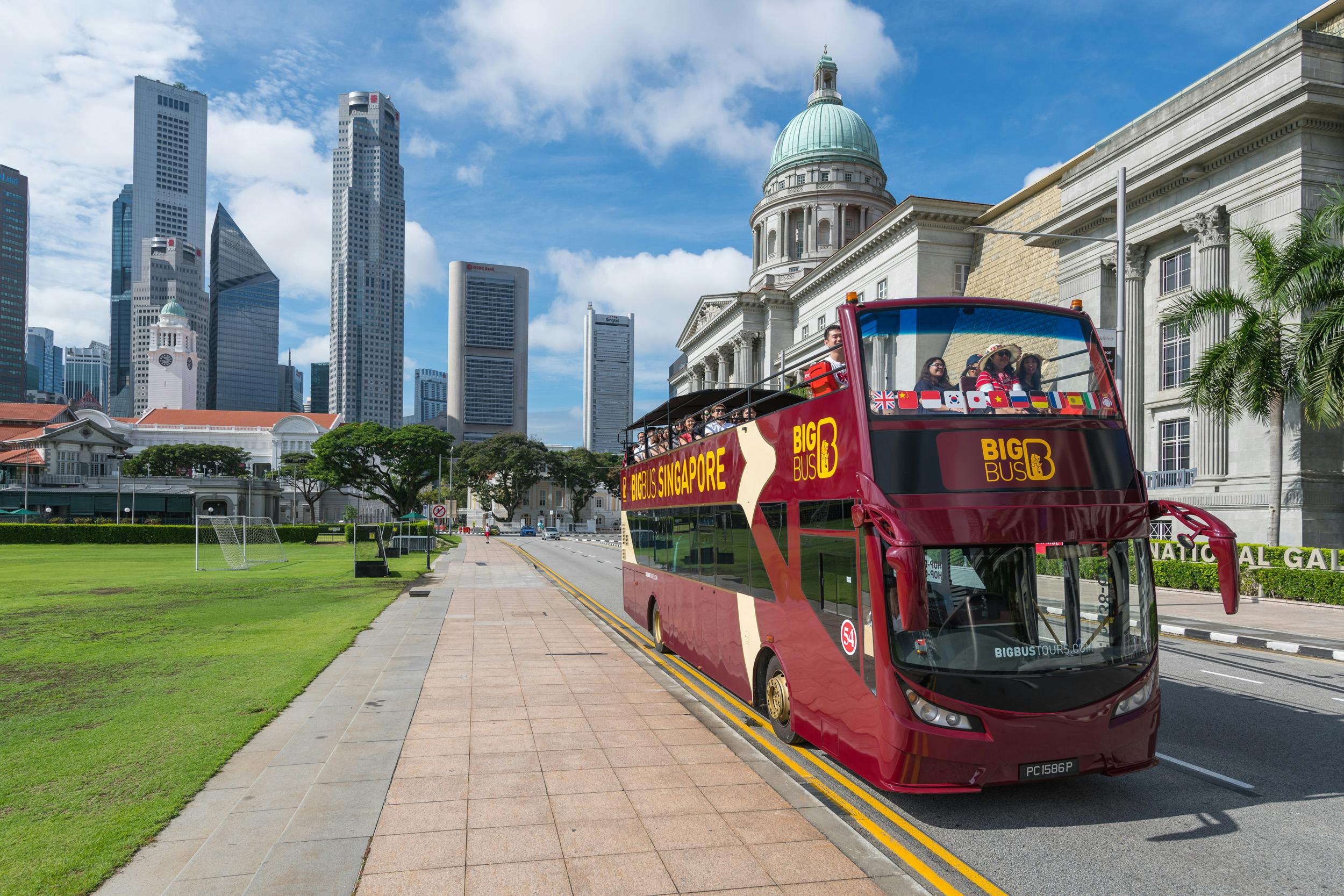Un temple asiàtic ornamentat de diversos pisos amb sostres escalonats sota un cel parcialment ennuvolat; una persona amb barret i samarreta de ratlles es veu en primer pla.
