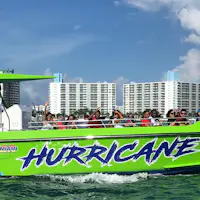 Un hors-bord vert vif nommé "Hurricane" avec des passagers, naviguant près de gratte-ciel sous un ciel bleu avec des nuages épars.