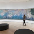 A young woman enjoying one of Monet's Water Lilies paintings at MoMA in New York City.