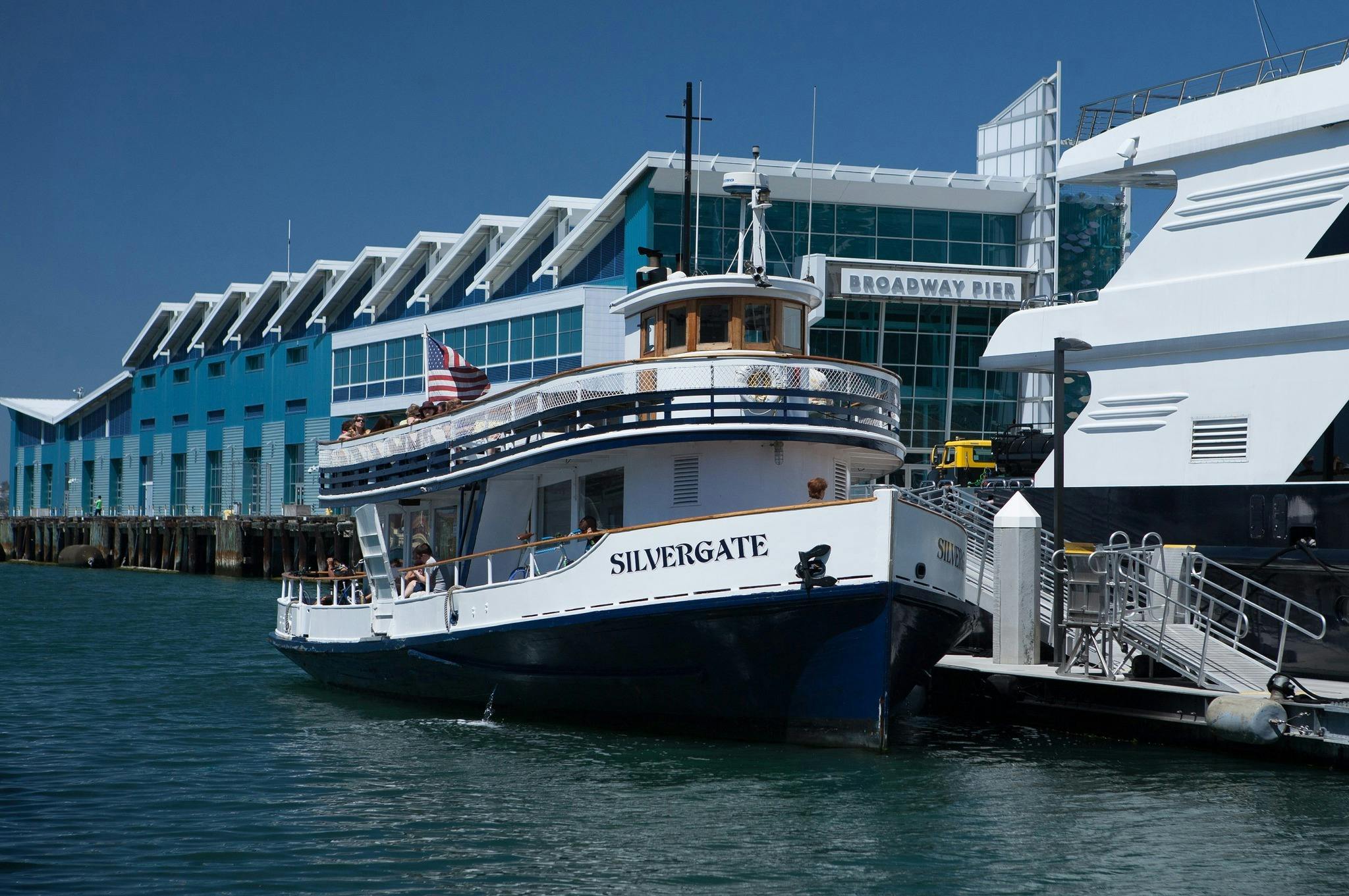 一艘名为“银门”的船停靠在一个码头，后面有一座标有“百老汇码头”的建筑。